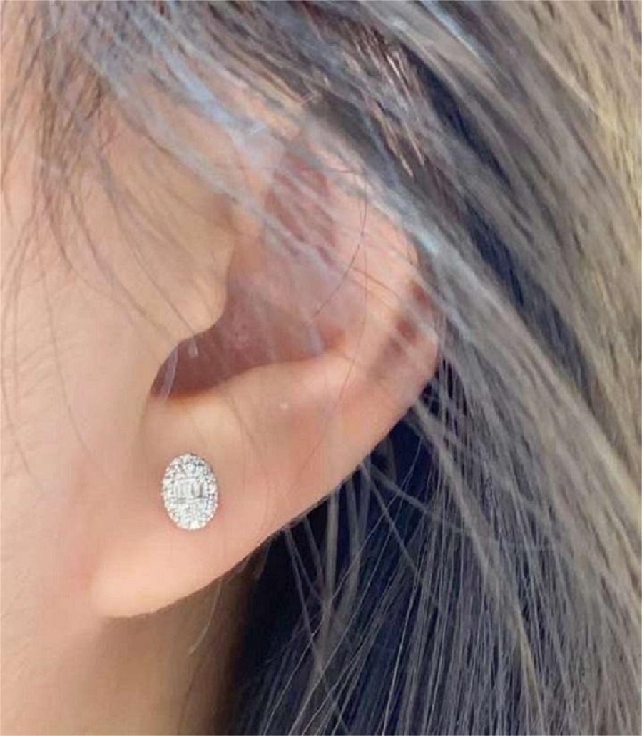 Oval diamond stud earring worn on ear