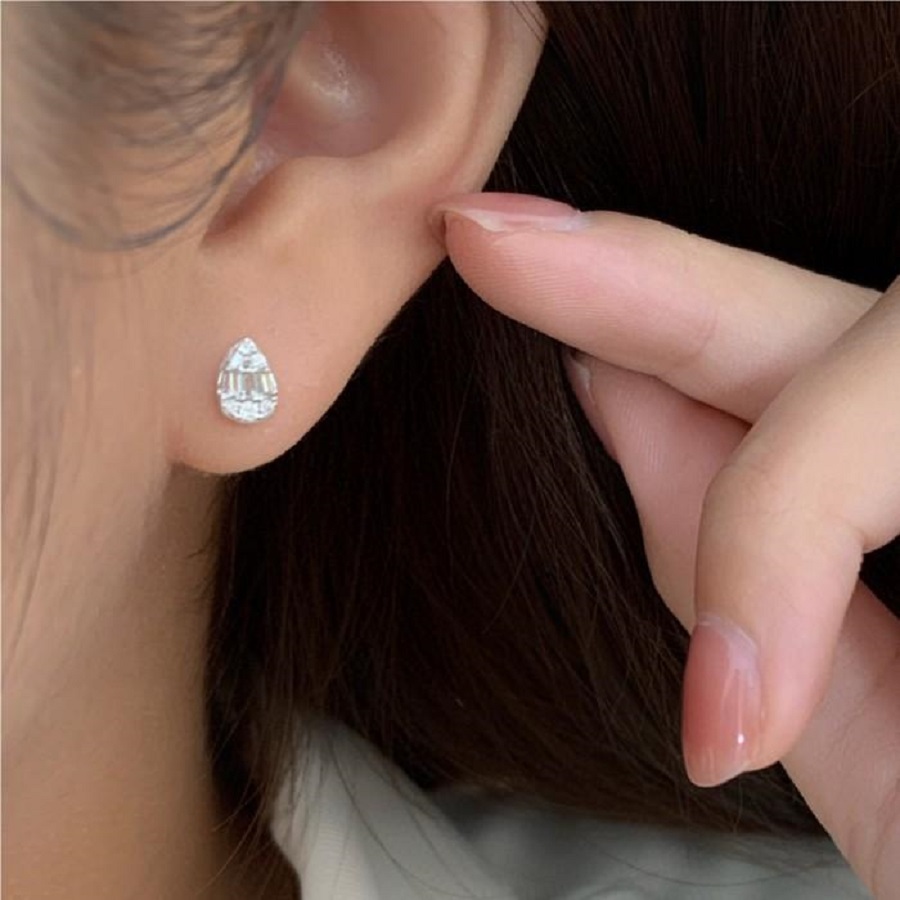 Teardrop diamond stud earring worn on ear
