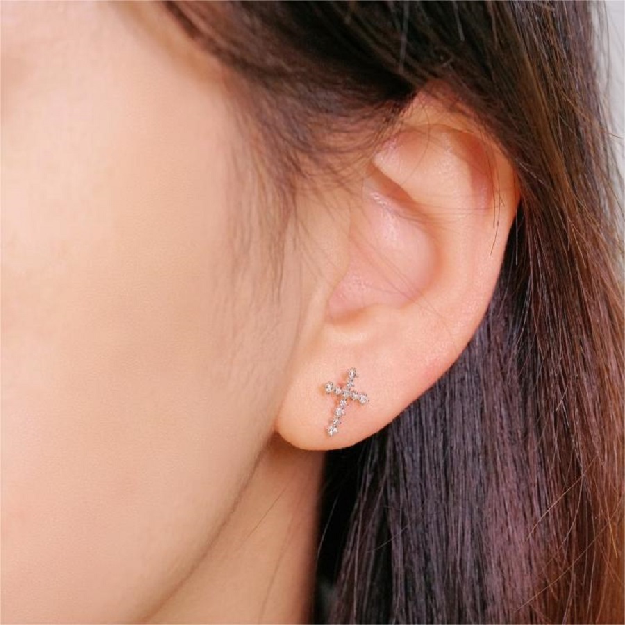 Cross diamond stud earring worn on ear